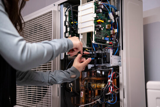 Technician's hands repairing air conditioner
