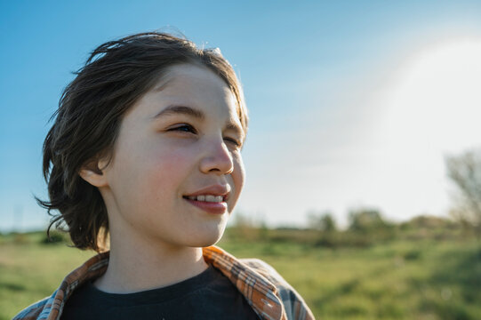 Smiling boy squinting on sunny day