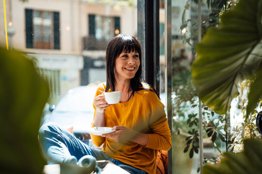 Smiling woman with coffee cup in cafe