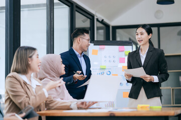 Professional business people taking part in a business meeting Discussing finances, strategies, and investing, they analyze charts on laptops. Demonstrate teamwork and effective communication.