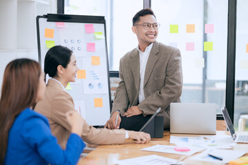 Professional business people taking part in a business meeting Discussing finances, strategies, and investing, they analyze charts on laptops. Demonstrate teamwork and effective communication.