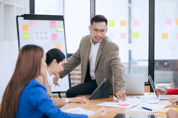 Professional business people taking part in a business meeting Discussing finances, strategies, and investing, they analyze charts on laptops. Demonstrate teamwork and effective communication.