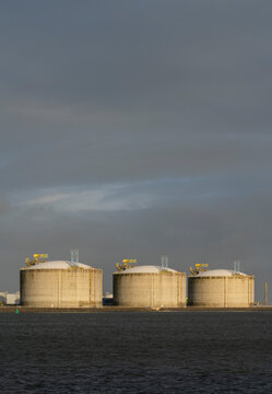 LNG tank under cloudy sky at port