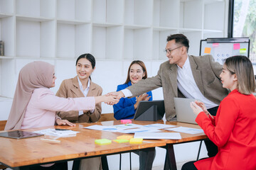 Asian professional team Including businessmen and businesswomen. Participate in corporate meetings Discuss strategy Analyze data on a laptop and brainstorm ideas for success