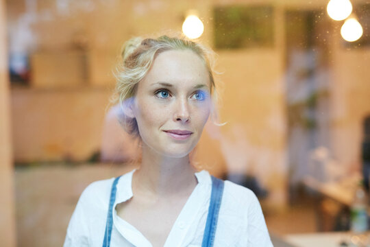 Smiling woman seen through glass in cafe
