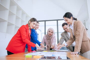 A young, Asian team in a modern office engages in a corporate meeting. brainstorm and present ideas, fostering teamwork and strategy for business success.
