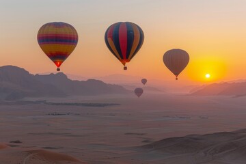 Obraz premium Hot Air Balloons Flying Over a Desert Landscape at Sunrise
