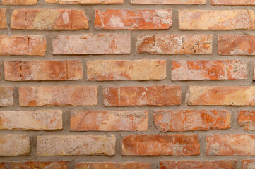 Obraz premium Sciana z pomarańczowych starych prostokątnych niedoskonałych cegieł z bliska, ceglaste tło