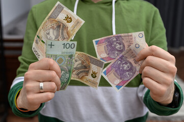 Mężczyzna trzyma w dłoniach polskie banknoty pln, kasa do wygrania