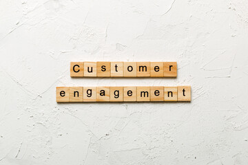Customer engagement word written on wood block. Customer engagement text on cement table for your...