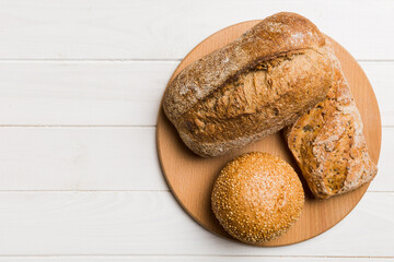 Freshly baked bread on cutting board against white wooden background. top view bread with copy space