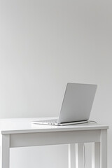 Fototapeta premium White laptop on a white table in a room with white walls