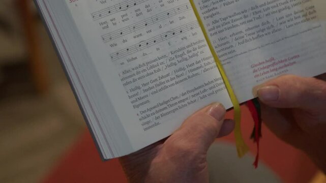 choir singing from catholic songbook during service in church