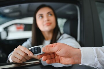 male adult dealer hand giving car keys to female person
