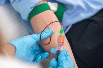 Nurse draws blood for lab tests, performing phlebotomy.