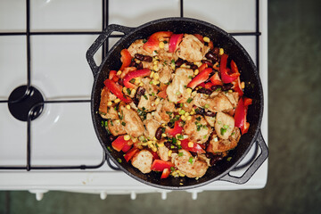 Top view of making chicken stew with vegetables in casserole on gas stove