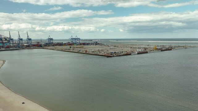 Aerial view of the new HUB terminal at Gdansk Stogi harbor with cranes and containers under a cloudy sky -the process of building a new transshipment terminal