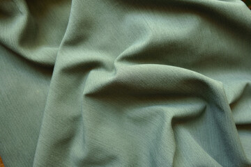 Crumpled reseda green polyester fabric with herringbone pattern