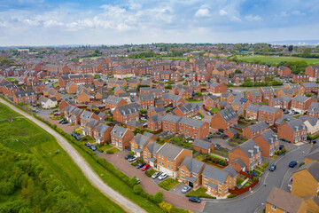Aerial photo of a typical British housing estate in the village of Middleton in Leeds West Yorkshire in the UK, showing a top down drone view of suburban streets, roads and rows of houses.