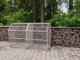 A metal barrier for waste bins in the forest, which serves as protection against damage by wild animals.