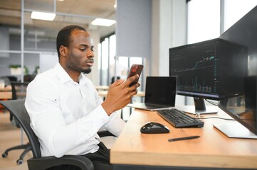 African-American broker works in office using workstation and analysis technology