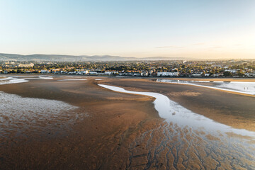 Sandymount Beach in Dublin at Sunset with Expansive Tidal Flats and Scenic Urban Backdrop under Clear Evening Sky