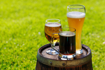 Variety of beer glasses on rustic wooden barrel