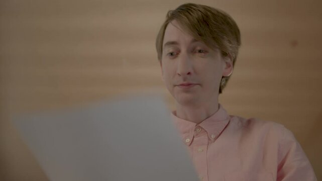 Nerdy Office Worker Picks Up a Document and Smiles Then Looks Surprised, Static Close Up