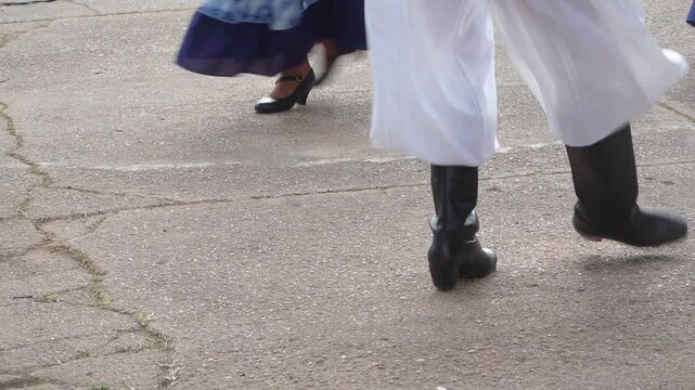 Closeup of the legs of dancers performing a chacarera, traditional argentinian folk dance.