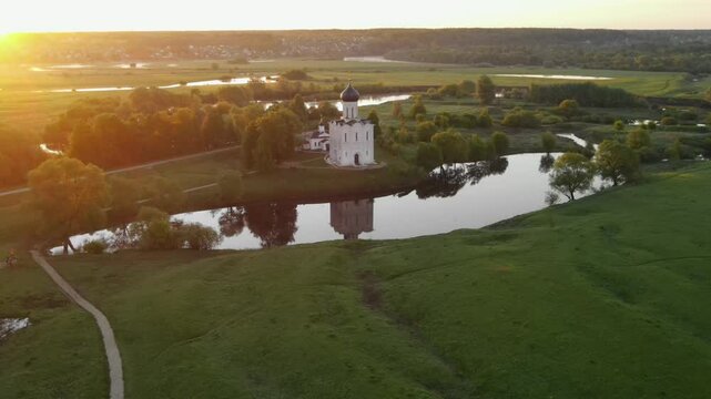 drone flight at dawn around the Orthodox Church of the Intercession of the Blessed Virgin Mary on the Nerl River, Bogolyubovo, Suzdal district, Vladimir region, Russia. High-quality 4k footage