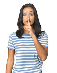 Young Latina posing in studio keeping a secret or asking for silence.