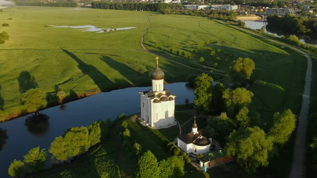 drone flight at dawn around the Orthodox Church of the Intercession of the Blessed Virgin Mary on the Nerl River, Bogolyubovo, Suzdal district, Vladimir region, Russia. High-quality 4k footage