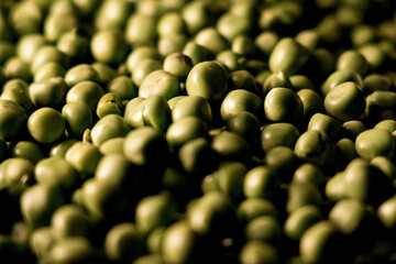 Green peas in a plate on a black background