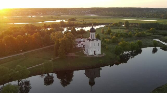 drone flight at dawn around the Orthodox Church of the Intercession of the Blessed Virgin Mary on the Nerl River, Bogolyubovo, Suzdal district, Vladimir region, Russia. High-quality 4k footage