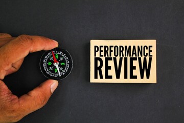 a compass and a square of paper with the word Performance review
