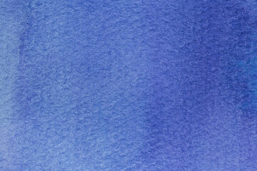 close up of spots of blue paint on textured watercolor paper