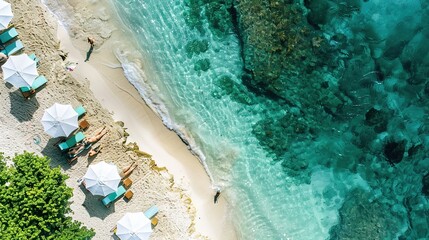 Aerial view of white sandy beach with umbrellas and chairs as well as clear sea water and coral reefs. Relaxing and peaceful concept