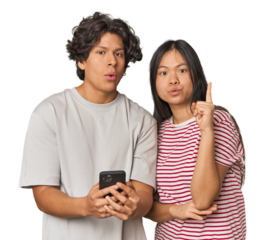 Young interracial couple using smartphone having some great idea, concept of creativity.