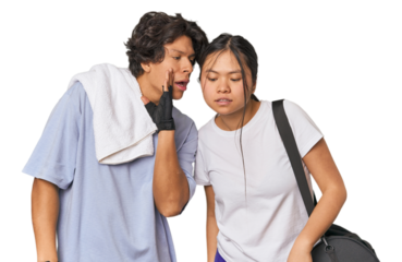 Young interracial athletic couple in studio is saying a secret hot braking news and looking aside