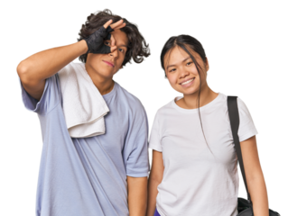 Young interracial athletic couple in studio excited keeping ok gesture on eye.