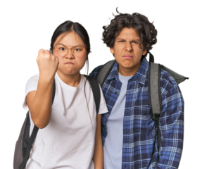Young interracial student couple studying showing fist to camera, aggressive facial expression.
