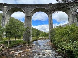 Fototapeta premium The arches of the Glenfinnan viaduct in Scotland seen from below with a white water flowing beneath it