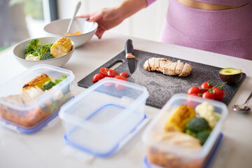 Close Up Of Woman Wearing Fitness Clothing At Home In Kitchen Making Healthy Meals For The Freezer