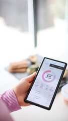 Close Up Of Woman Looking At Calorie Counting App On Mobile Phone At Home