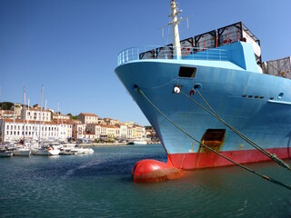 Blue container ship in the middle of a picturesque French town on the Mediterranean coast.