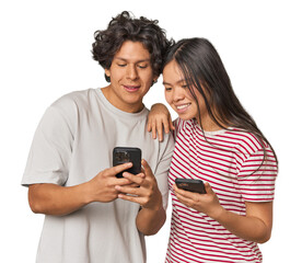 Multiracial young couple engaged with smartphones in studio