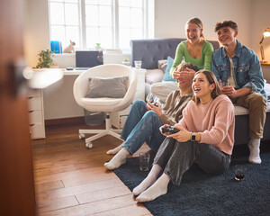 Group Of Teenage Girls And Boys At Home In Bedroom Together Playing Computer Games Together