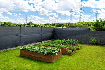 Anthracite-colored masking net placed on a mesh fence, visible vegetable boxes.