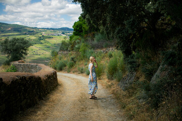 Obraz premium Amidst the picturesque vineyards of the Douro Valley in Portugal, a middle-aged woman enjoys a delightful wine tour.