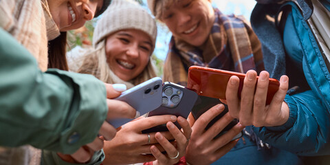 Obraz premium Close Up Of Group Of Teenage Girls And Boys Outdoors Dressed For Winter All Holding Mobile Phones